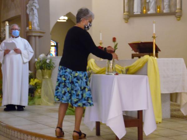 Second Vice Regent Deborah Brown places a red rose in a vase as part of the installation of officers on May 13, 2021, at St. Monica's Church in Barre.